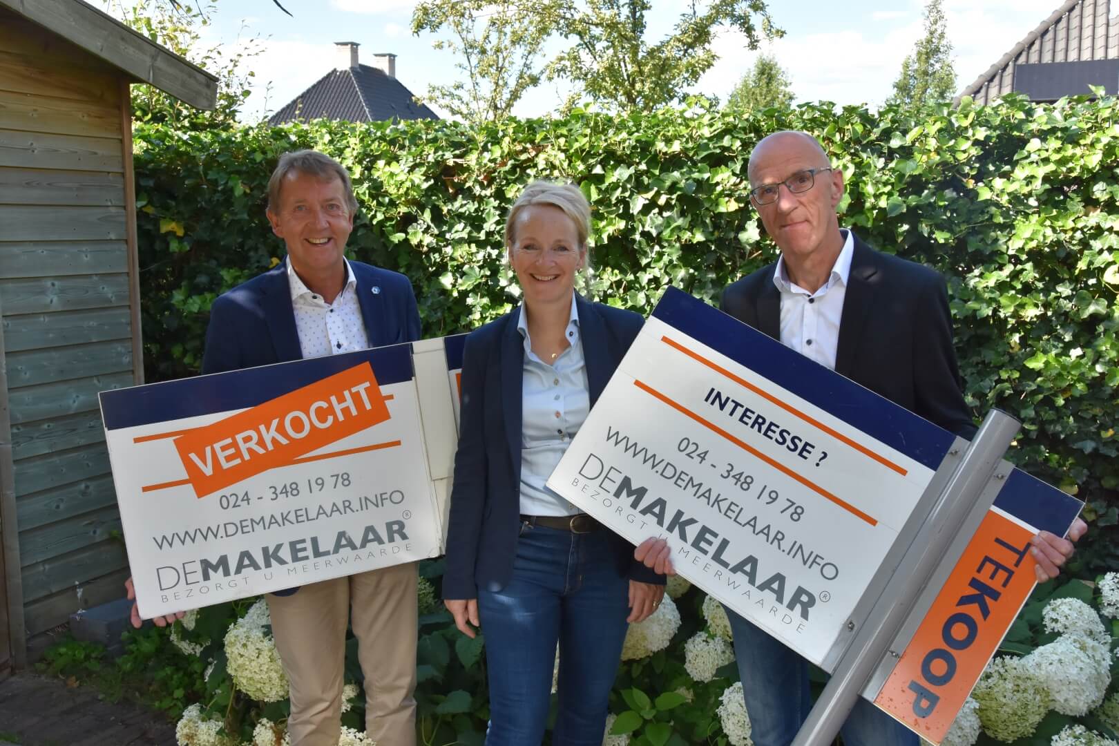 Medewerkers van DeMakelaar in Wijchen met hun verkoopborden